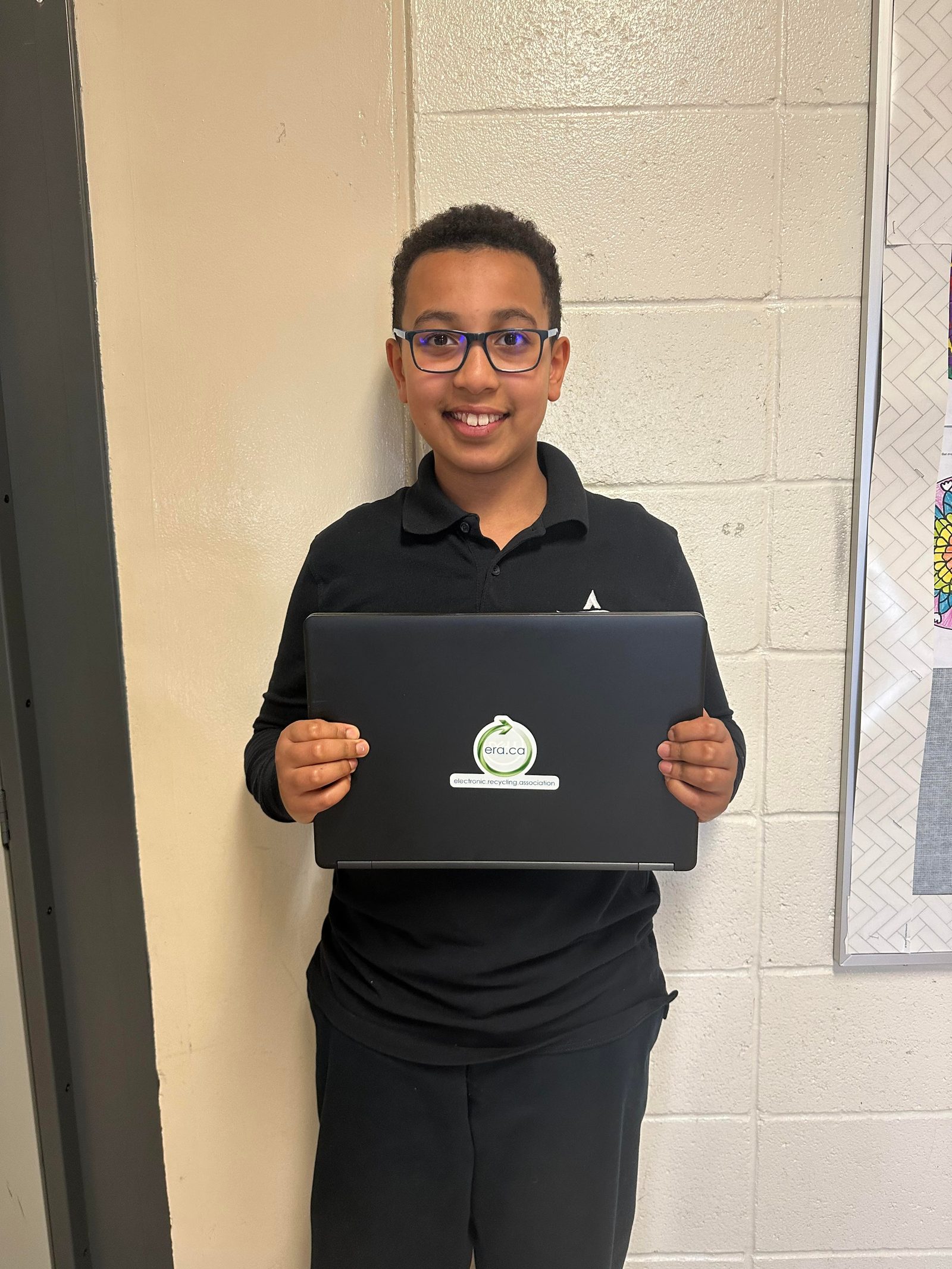 A student holding his refurbished laptop