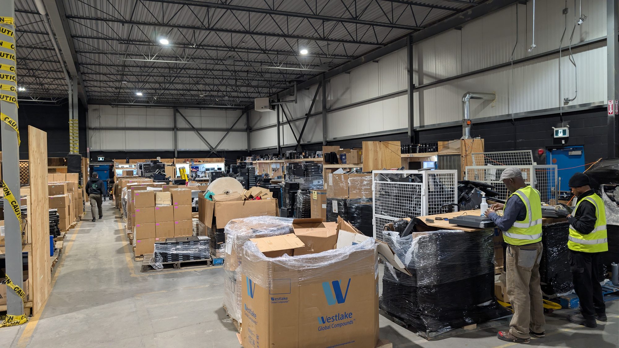 Workers in safety vests sorting donated equipment in an ERA warehouse